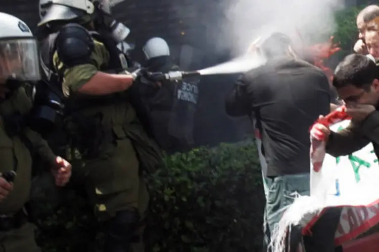 Policiais jogam gás lacrimogênio em manifestantes que protestavam contra políticas de austeridade e os planos de privatização do governo (Milos Bicanski/Getty Images)