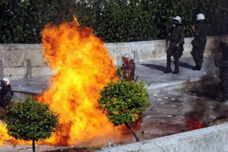 Os policiais usaram gás lacrimogêneo e armas para dispersar os manifestantes, que lançaram pedras e bombas incendiárias nos agentes 
 (Aris Messinis/AFP)