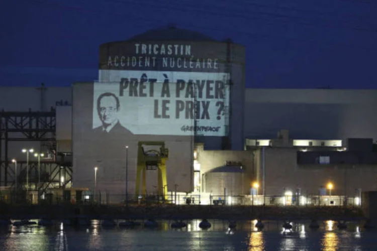 
	Rosto do presidente Fran&ccedil;ois Hollande e os dizeres: &quot;Tricastin, acidente nuclear. Dispostos a pagar o pre&ccedil;o?&quot; s&atilde;o projetado pelo Greenpeace na usina nuclear de Tricastin
 (REUTERS / Micha Patault / Greenpeace)