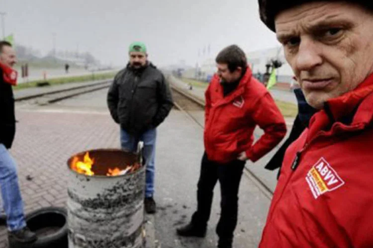 Grevistas diante da companhia Bayer, no porto da Antuérpia: os principais sindicatos esperam paralisar o país com um chamado à greve tanto no setor público quanto no privado
 (Dirk Waem/AFP)
