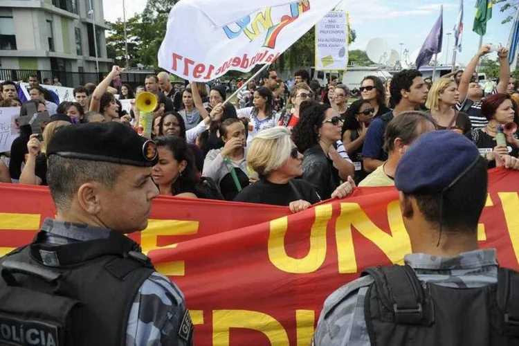 
	Professores do Rio protestam durante a sa&iacute;da do &ocirc;nibus com jogadores da Sele&ccedil;&atilde;o Brasileira
 (Tânia Rêgo/Agência Brasil)