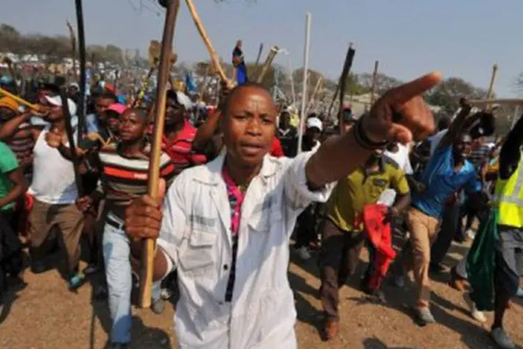 Mineiros sul-africanos em greve protestam: os grevistas pedem um salário de R$ 3 mil e a companhia oferece um valor de R$ 1,3 mil (Alexander Joe/AFP)