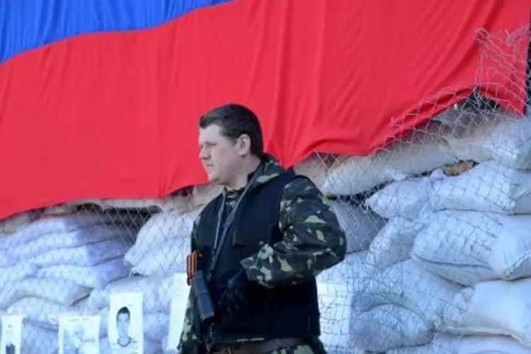 
	Homem armado monta guarda em frente a edif&iacute;cio de Slaviansk: membros da UE seguem relutantes em aplicar san&ccedil;&otilde;es econ&ocirc;micas mais amplas no atual est&aacute;gio
 (Kirill Kudriavtsev/AFP)