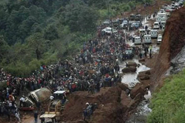 Pessoas se aglomeram ao redor de ônibus soterrado por delizamento de terra em rodovia da capital guatemalteca de Tecpan. (.)