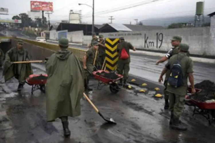 Soldados limpam as cinzas do vulcão Pacaya nas ruas de Las Calderas, Guatemala (.)