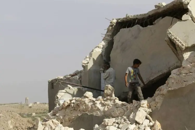 
	Menino junto com os destro&ccedil;os de um pr&eacute;dio danificado ao sul da periferia de Idlib, na S&iacute;ria
 (Khalil Ashawi/Reuters)