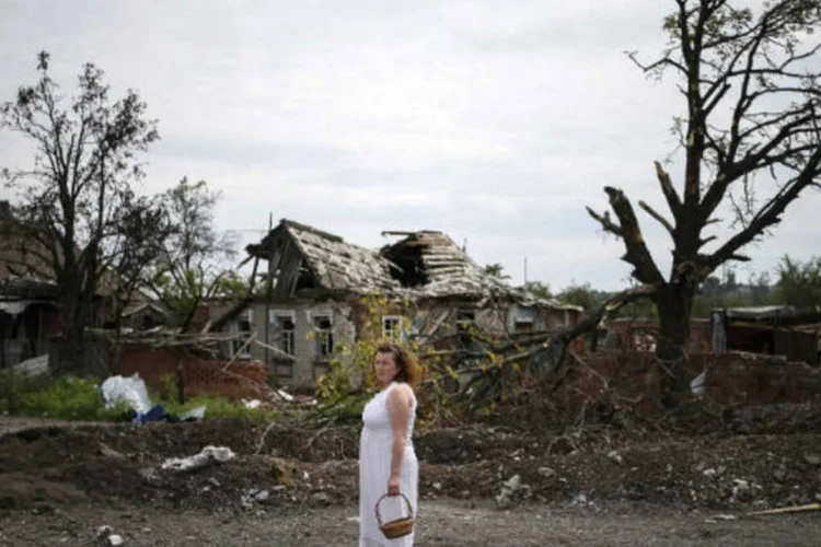 
	Mulher observa destrui&ccedil;&atilde;o na Ucr&acirc;nia: Anna passou seis dias em cativeiro e foi torturada
 (REUTERS/Gleb Garanich)