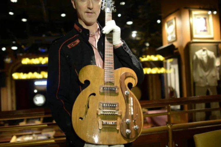 Martin Nolan, diretor executivo da casa de leilão Julien's, exibe a guitarra de seis cordas Vox, tocada pelos Beatles (AFP / Timothy Clary)