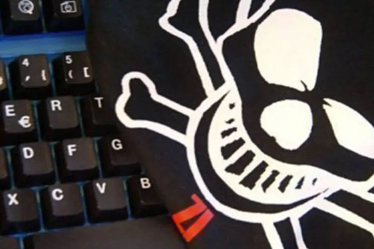 
	Imagem de pirata sobre um teclado de computador: para tentar proteger o sistema financeiro desses ataques, as autoridades prop&otilde;em &quot;melhorar a coopera&ccedil;&atilde;o entre os setores&quot;
 (Joel Saget/AFP)