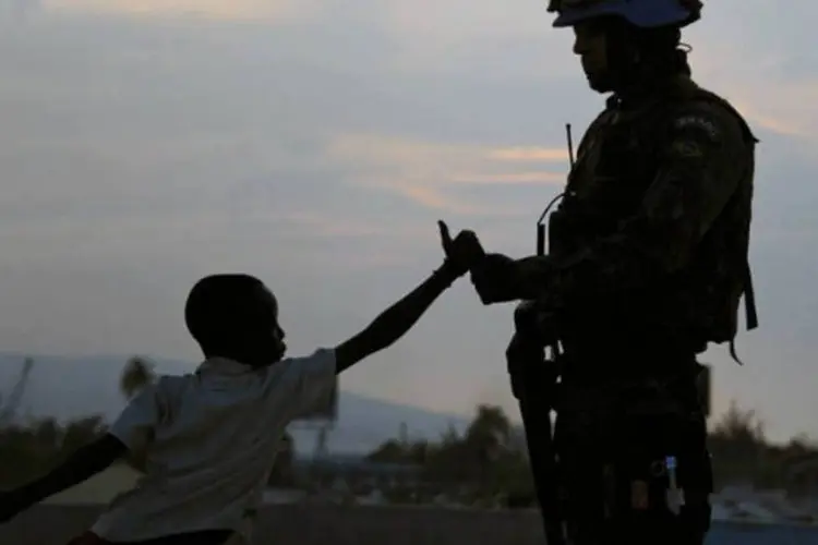
	Soldado brasileiro da Minustah cumprimenta haitiano em favela de Porto Pr&iacute;ncipe: em abril passado, o Brasil iniciou uma redu&ccedil;&atilde;o de suas tropas, que em meados de 2013 era de 1.200 militares
 (AFP / Vanderlei Almeida)
