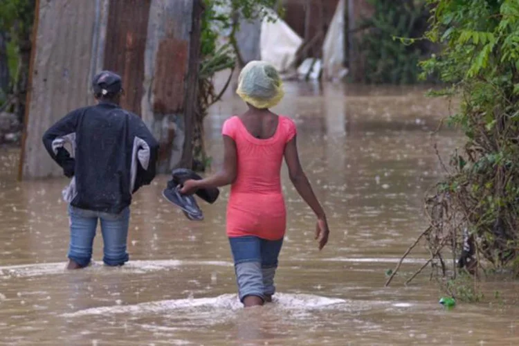 
	Haitianos atravessam uma rua inundada pelas chuvas provocadas pelo furac&atilde;o Sandy em Porto Pr&iacute;ncipe
 (REUTERS/Swoan Parker)