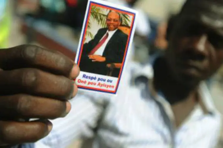 Haitiano com foto do ex-presidente Aristide: prometendo apoio logístico da missão da ONU ao país, enviada especial Sandra Honoré insistiu na necessidade de eleições (AFP)