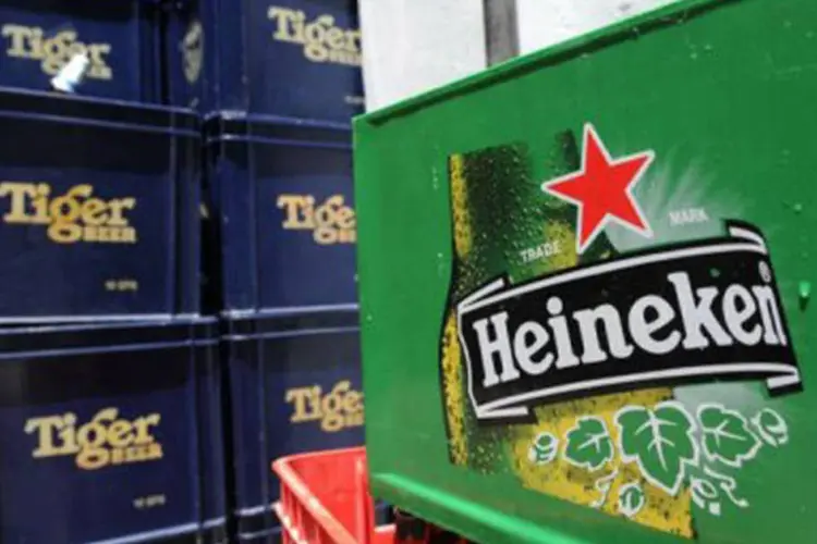 
	Engradados de cervejas Heineken e Tiger s&atilde;o empilhados em de Cingapura: com aquisi&ccedil;&atilde;o de 40% da APB, a Heineken ambiciona conquistar o mercado da cerveja na &Aacute;sia
 (Roslan Rahman/AFP)