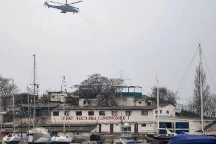 Helicóptero militar russo sobrevoa o porto de Sebastopol, Crimeia: em Moscou, mais 65 mil pessoas se reuniram para um evento em apoio aos habitantes da Crimeia (Filippo Monteforte/AFP)