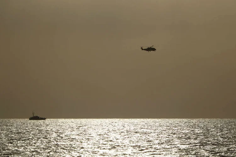 
	Helic&oacute;ptero italiano faz busca no mediterr&acirc;neo ap&oacute;s naufr&aacute;gio na costa da L&iacute;bia: segundo a 1&ordf; reconstitui&ccedil;&atilde;o, a aproxima&ccedil;&atilde;o de um navio de resgate assustou muitos imigrantes, que se amontoaram no mesmo lado do navio, fazendo com que ele tombasse
 (Reuters/ Darrin Zammit)