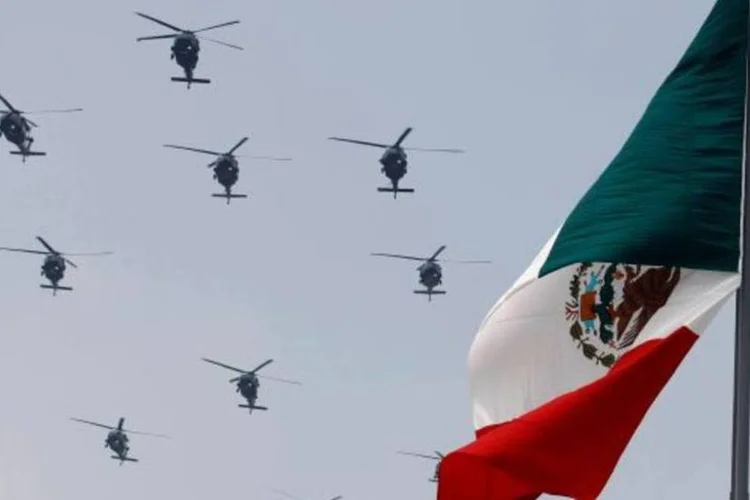 
	Helic&oacute;pteros da For&ccedil;a A&eacute;rea sobrevoam a bandeira do M&eacute;xico: o pa&iacute;s sofre com a a&ccedil;&atilde;o dos cart&eacute;is de tr&aacute;fico de drogas, armas e pessoas
 (Bernardo Montoya/Reuters)