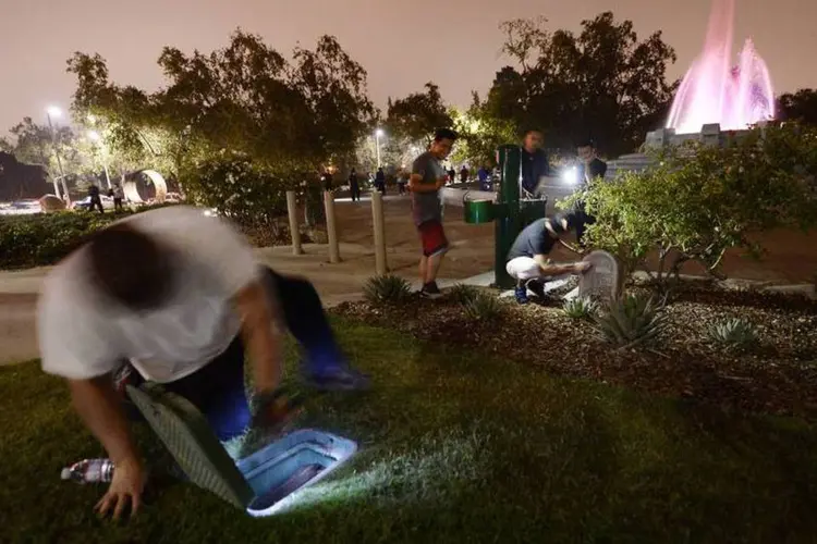 
	Pessoas procuram por dinheiro escondido em um parque de Los Angeles
 (Kevork Djansezian/Reuters)
