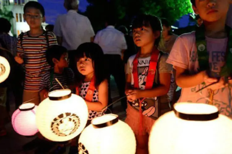 Crianças carregam lanternas em homenagem aos mortos de Hiroshima, no Japão (AFP / Toru Yamanaka)