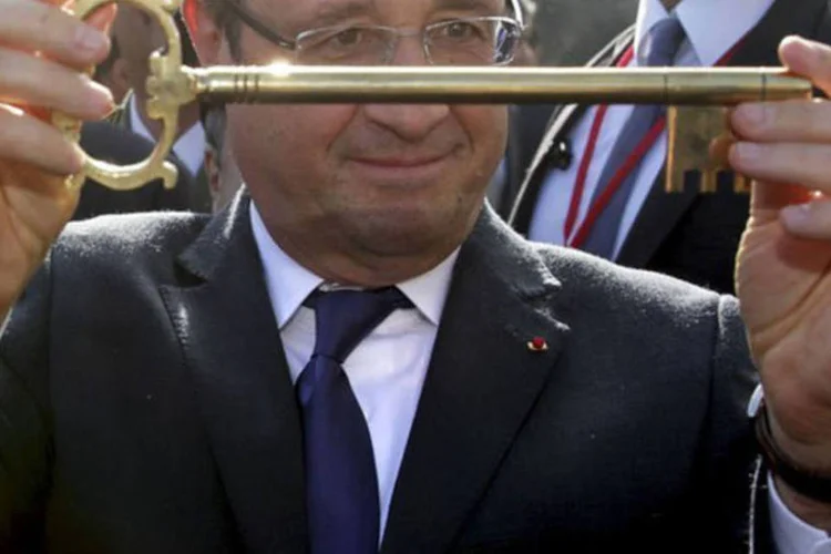 
	Fran&ccedil;ois Hollande, presidente da Fran&ccedil;a, mostra a chave de Argel: ele prometeu melhorar o tratamento dado aos argelinos que tentam obter vistos para viajar a Fran&ccedil;a
 (Philippe Wojazer/AFP)