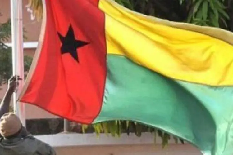 
	Homem agita bandeira da Guin&eacute;-Bissau: maioria da popula&ccedil;&atilde;o da Guin&eacute;-Bissau sobrevive com menos de R$ 6 por dia
 (Foto/AFP)