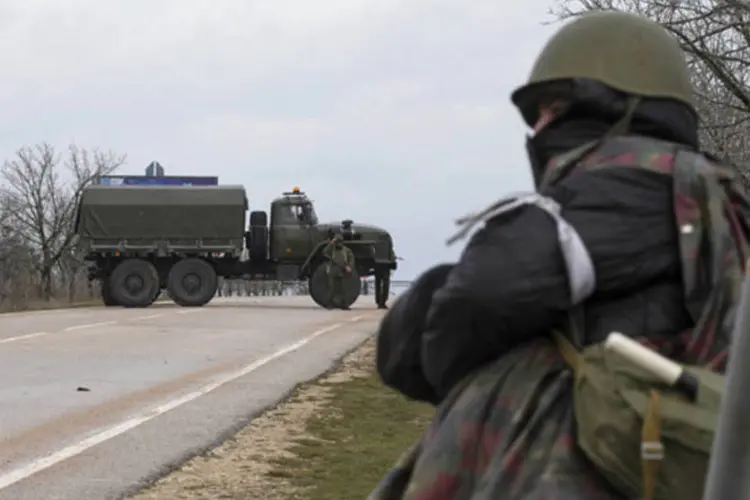 
	Homem armado de guarda em frente a aeroporto na Crim&eacute;ia: chefe de governo&nbsp;disse desconhecer os movimentos das tropas russas na pen&iacute;nsula
 (Baz Ratner/Reuters)