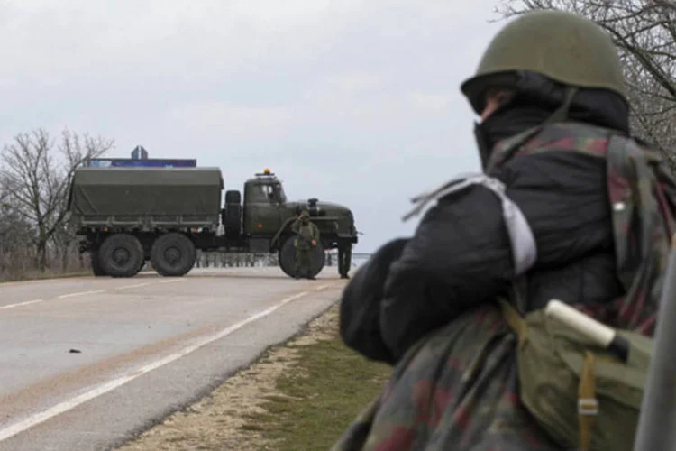
	Homem armado de guarda em frente a aeroporto na Crim&eacute;ia: autoridades dos EUA disseram que Washington tem visto indica&ccedil;&otilde;es de movimentos de tropas na regi&atilde;o
 (Baz Ratner/Reuters)