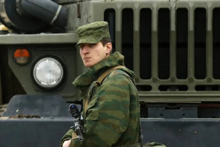 Homem armado, que se acredita estar a serviço da Rússia, monta guarda no em frente a uma área militar ucraniana na cidade de Sevastopol, na região da Crimeia (David Mdzinarishvili/Reuters)