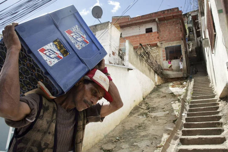 Homem carrega caixa de cerveja em Caracas, na Venezuela (Mario Tama/Getty Images)