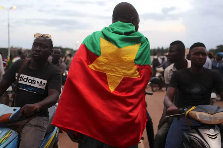 
	Homem com bandeira de Burkina Faso em protesto: o l&iacute;der do golpe, ex-chefe do Estado-Maior no antigo governo de Blaise Campaor&eacute;, que foi derrubado por uma revolta popular no final do ano passado
 (Reuters / Joe Penney)