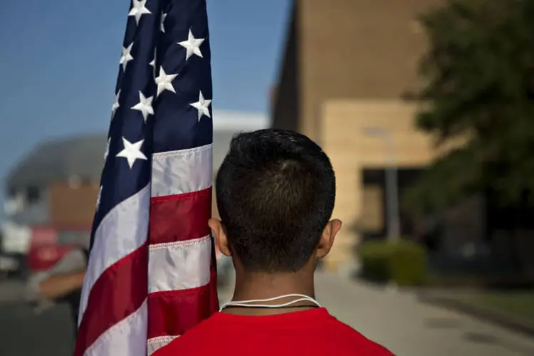 Rapaz com bandeira americana: o país sofreu muito com a crise - mas ela poderia ter sido pior (Daniel Acker/Bloomberg)