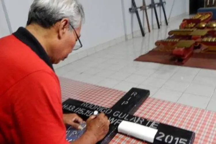
	Homem pinta cruz de Rodrigo Gularte, o brasileiro no corredor da morte na Indon&eacute;sia
 (AFP/ AZKA)