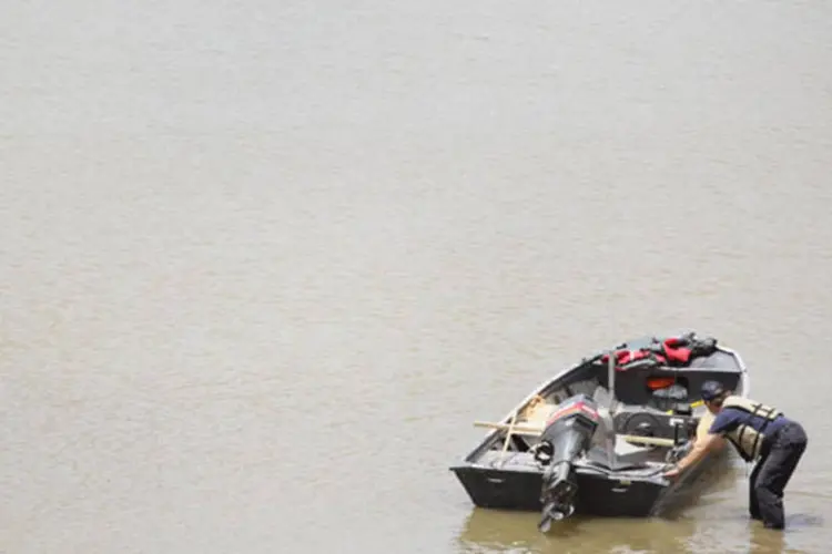 Homem empurra barco na cheia do Rio Mississipi (Scott Olson/Getty Images)