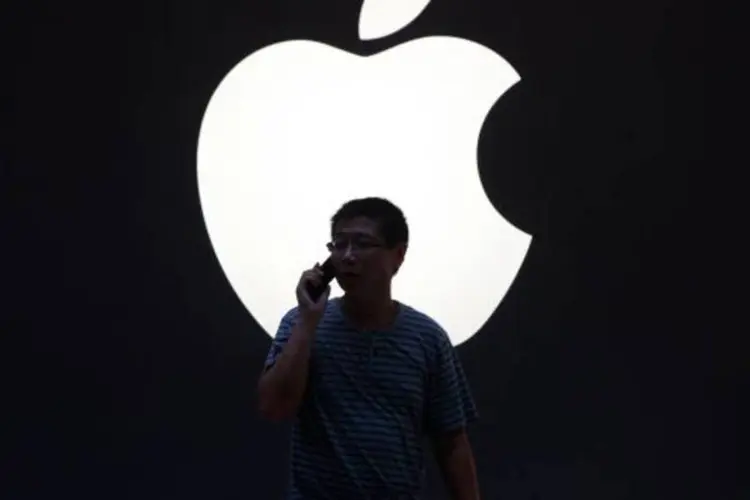 
	Homem fala no celular na frente do logo da Apple, em Xangai, na China: analistas dizem que a a&ccedil;&atilde;o da Apple continua uma s&oacute;lida aposta de longo prazo
 (Aly Song/Reuters)