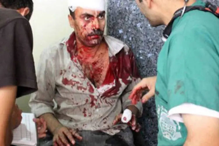 
	Homem ferido em ataque das tropas s&iacute;rias recebe atendimento m&eacute;dico em Alepo: helic&oacute;pteros do ex&eacute;rcito atacaram a regi&atilde;o
 (Antonio Pampliega/AFP)
