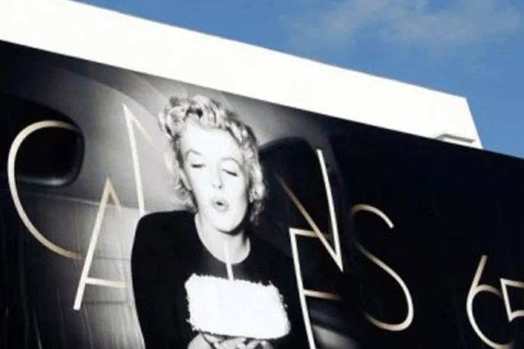 Homem fixa cartaz oficial do Festival na fachada do palácio de Cannes
 (Valery Hache/AFP)