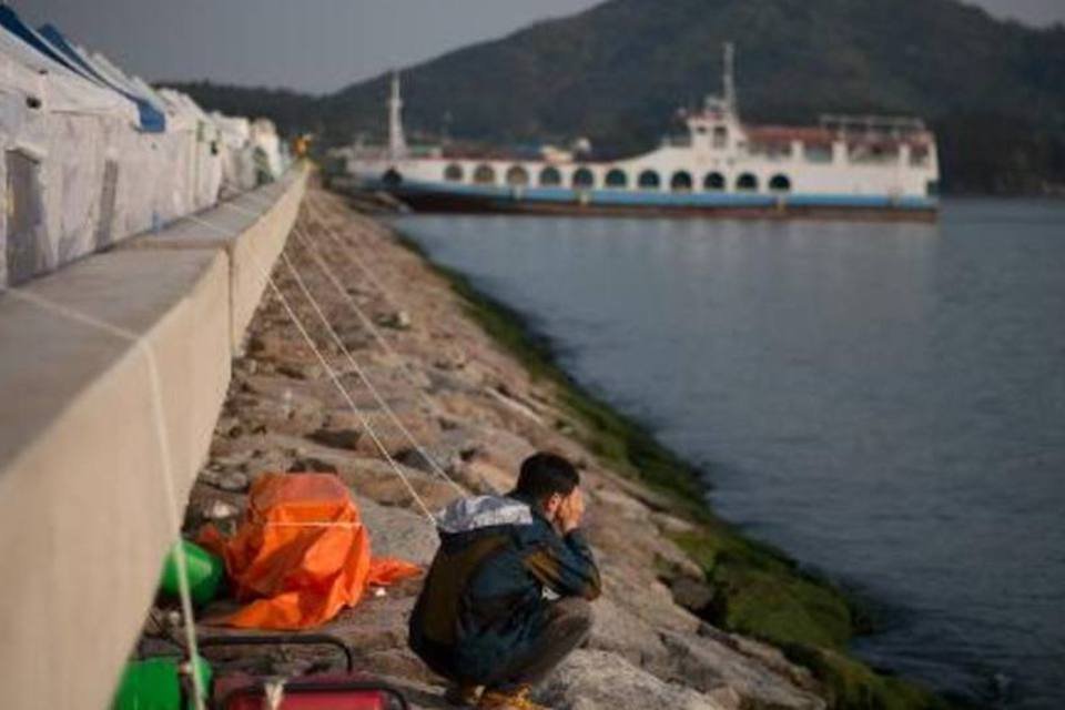 Homem na beira do mar próximo de local onde parentes e amigos das vítimas do naufrágio estão reunidos: mais de 160 pessoas seguem desaparecidas (Ed Jones/AFP)