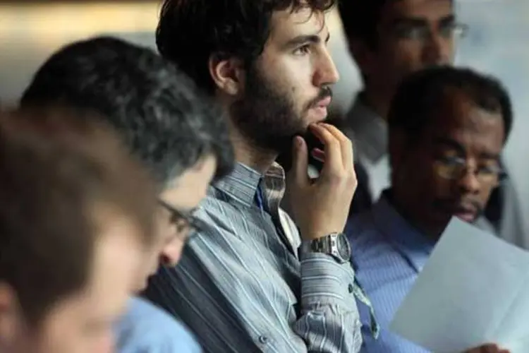 Homem pensando próximo de outros homens (Getty Images)