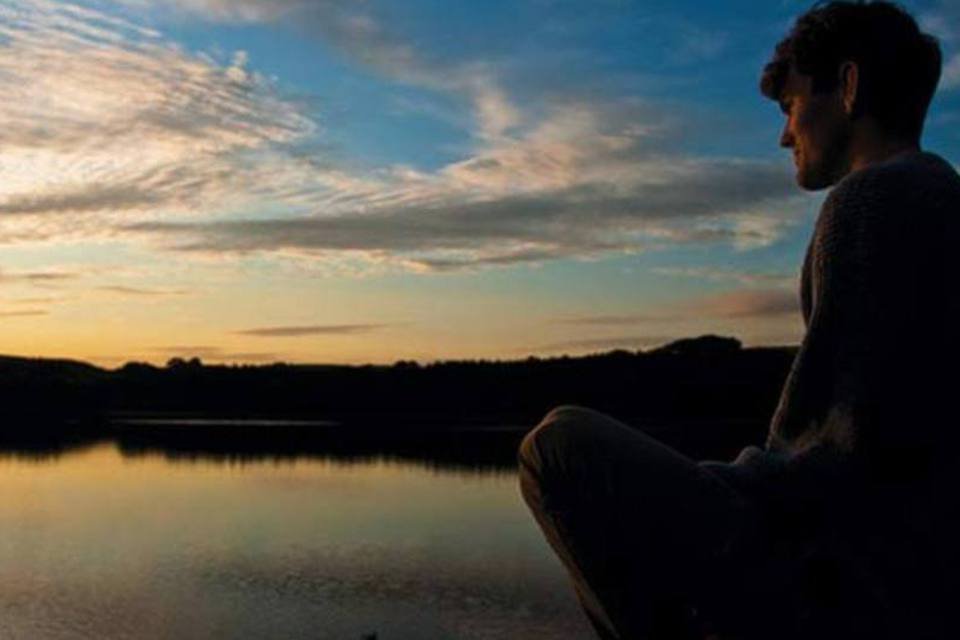 Homem pensando em frente a um lago com pôr-do-sol (Creative Commons/Flickr/Suicine)