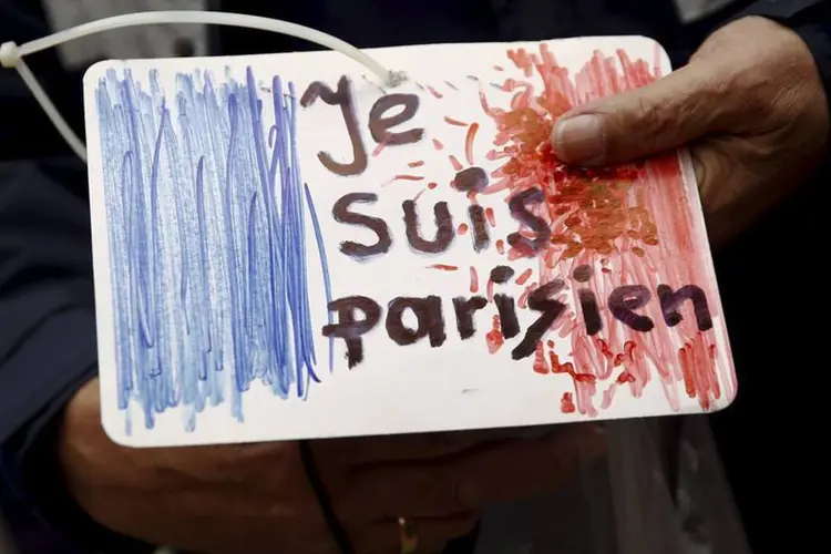 
	Homem segura desenho com frase &quot;Je sui parisien&quot; na Pol&ocirc;nia, um dia ap&oacute;s ataques na Fran&ccedil;a
 (Reuters)