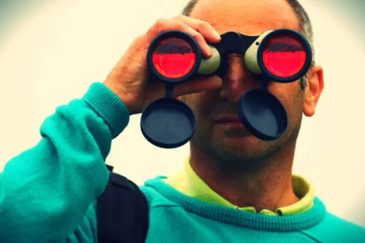Homem olha através de binóculo: no futuro, autogestão será realidade no trabalho (Getty Images/Getty Images)