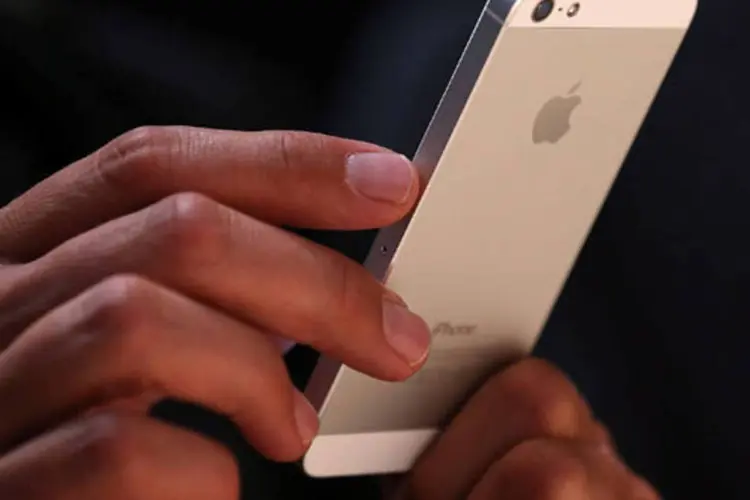 
	Homem segura iPhone 5: defeito faz com que o bot&atilde;o pare de funcionar ou s&oacute; funcione de forma intermitente
 (Getty Images)