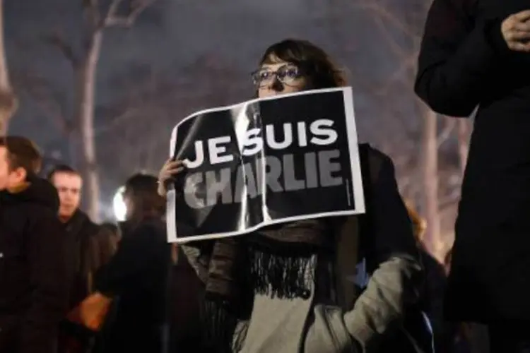 Mulher participa de ato em homenagem às vítimas do atentado que matou doze pessoas em Paris (Martin Bureau/AFP)