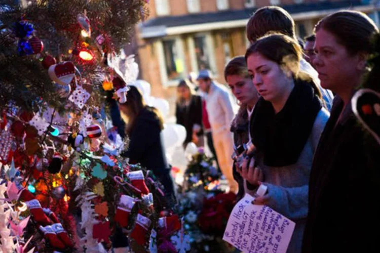 Pessoas prestam memórias às vítimas do tiroteio: nesta quarta-feira, as famílias foram convidadas a conhecer a nova escola na cidade próxima de Monroe (©afp.com / Andrew Burton)