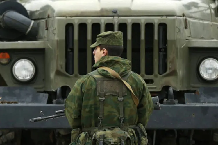 Homem armado, que se acredita estar a serviço da Rússia, monta guarda no em frente a uma área militar ucraniana na cidade de Sevastopol, na região da Crimeia (David Mdzinarishvili/Reuters)