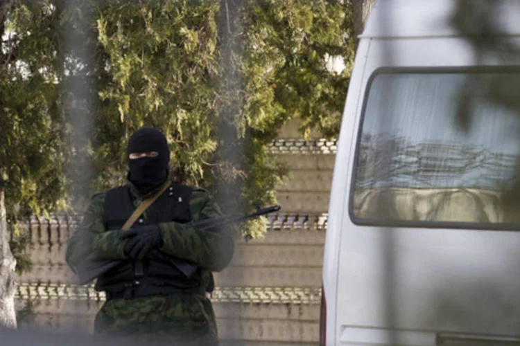 Homem armado, possivelmente russo, em base perdida pelos ucranianos, na cidade de Bakhchisaray, na Crimeia (Thomas Peter/Reuters)