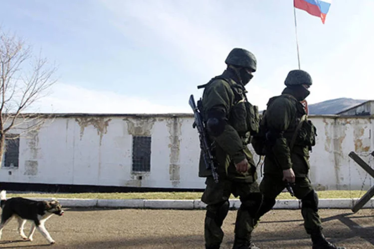 Tropas tidas como forças militares russas andam pelo lado de fora de uma base militare ucraniana, na vila de Perevalnoye, próxima a Simferopol (Vasily Fedosenko/Reuters)