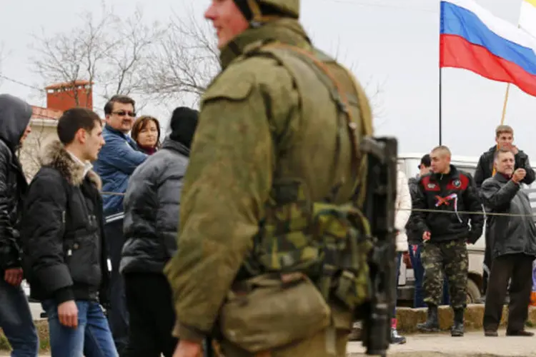 Homens armados montam guarda na cidade portuária de Feodosiya, na região da Crimeia, na Ucrânia (Thomas Peter/Reuters)