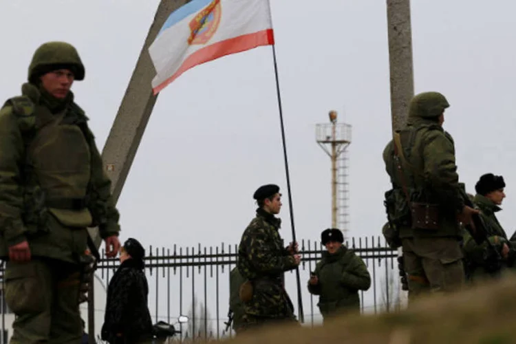 Homens armados montam guarda na cidade portuária de Feodosiya, na região da Crimeia, na Ucrânia (Thomas Peter/Reuters)