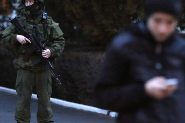 Homens armados montam guarda no aeroporto de Simferopol, na região da Crimeia (David Mdzinarishvili/Reuters)