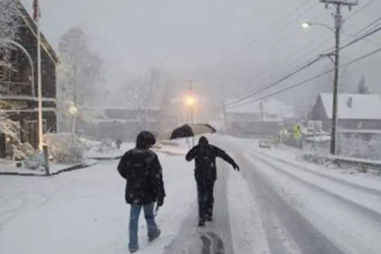 Homens caminham por uma rua coberta de neve: nevasca foi uma surpresa